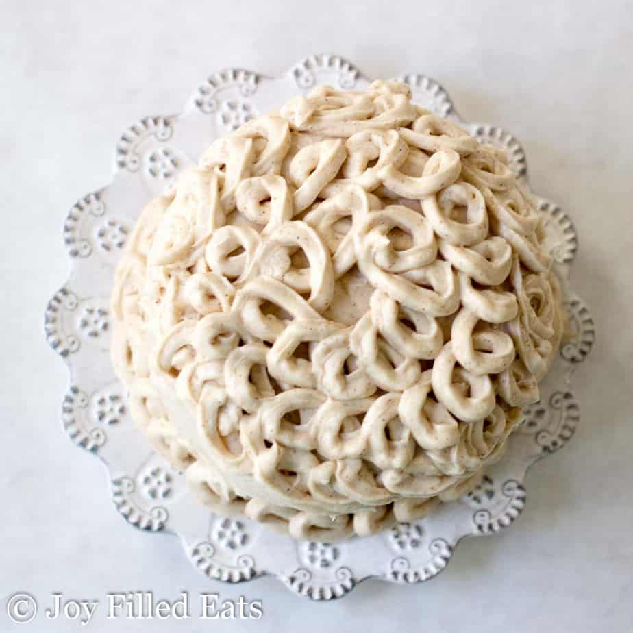 overhead view of decorative icing on mini snickerdoodle layer cake on a white plate