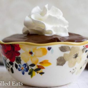 bowl filled to the brim with rich chocolate pudding and topped with whipped cream