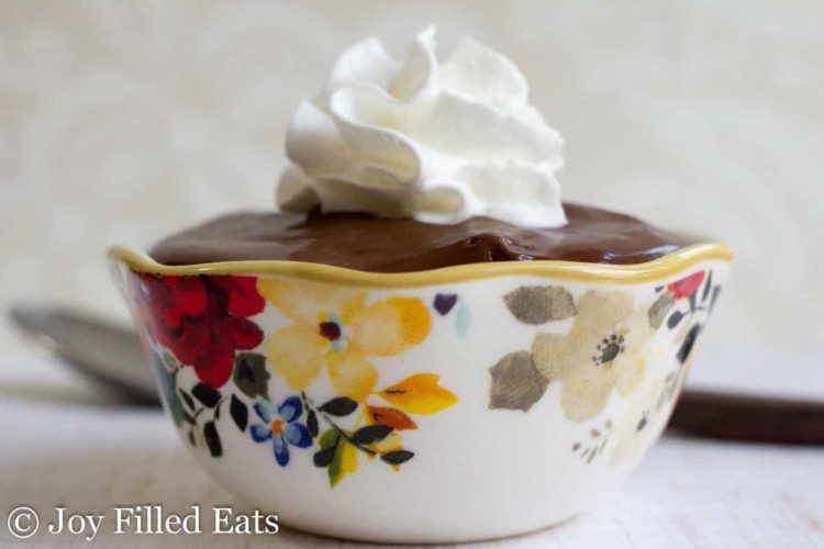 bowl filled to the brim with rich chocolate pudding and topped with whipped cream