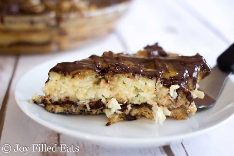 slice of chocolate caramel Samoas coconut pie laying on a serving spatula laying on a white plate