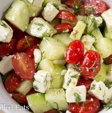 simple Greek tomato & cucumber salad in a white bowl close up