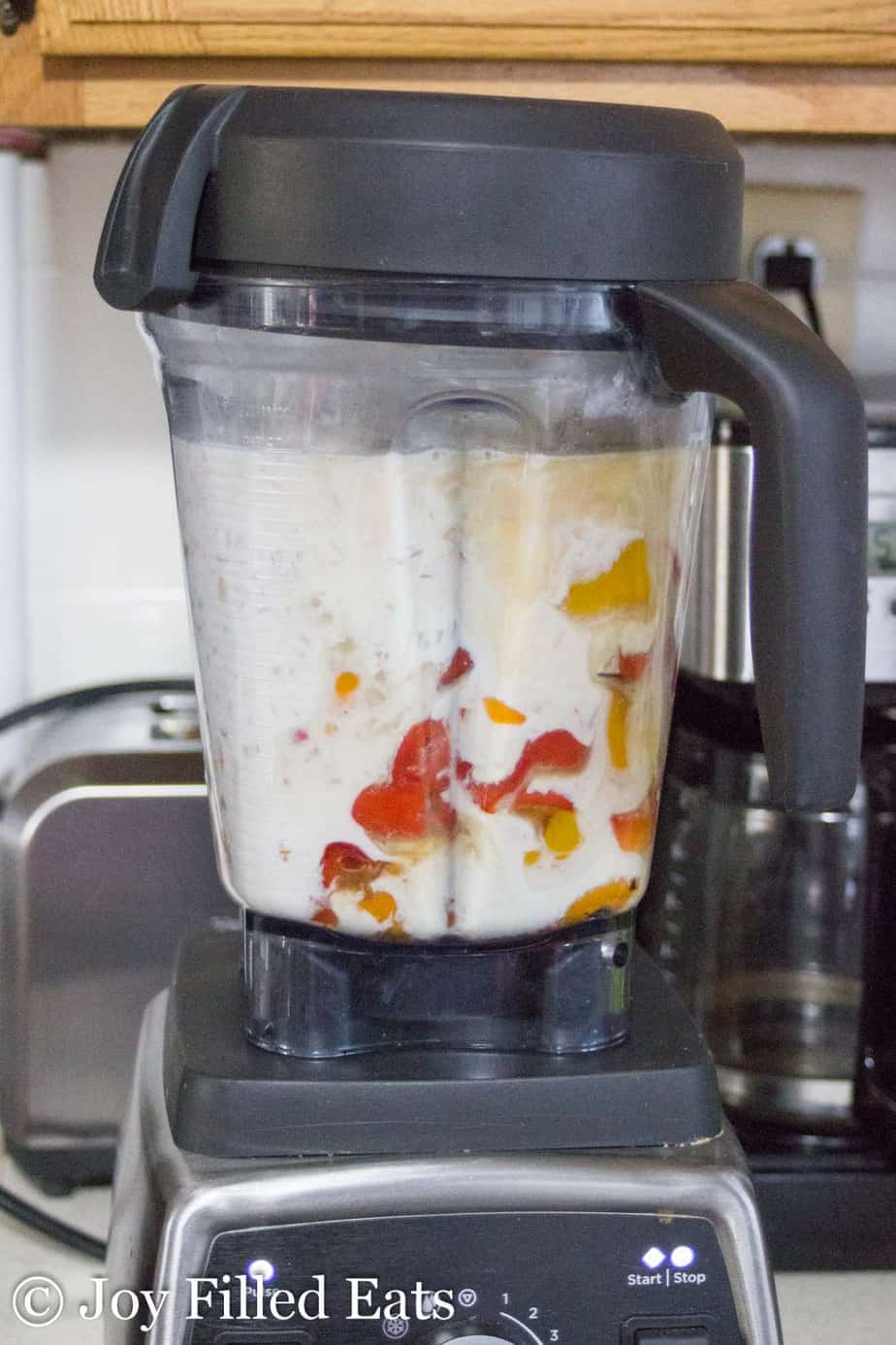 blender full of roasted red peppers and ingredients for soup