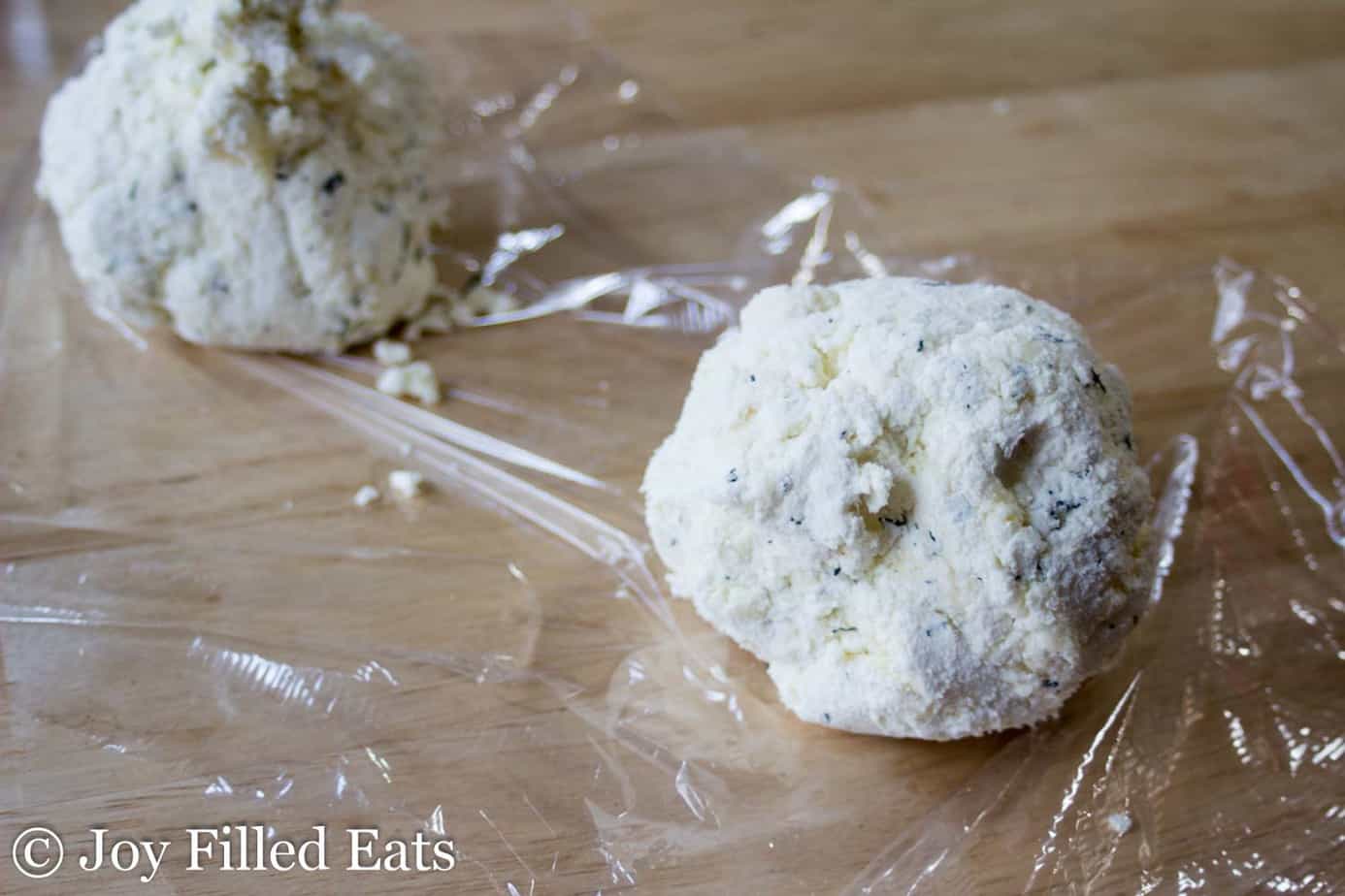 large feta & dill cheese balls sitting on a sheet of cellophane