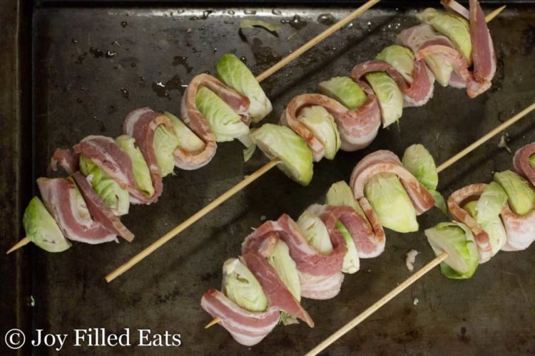 sheet pan lined with bacon & Brussels sprout kebabs before baking