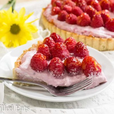 slice of raspberry mousse tart on a plate with a fork