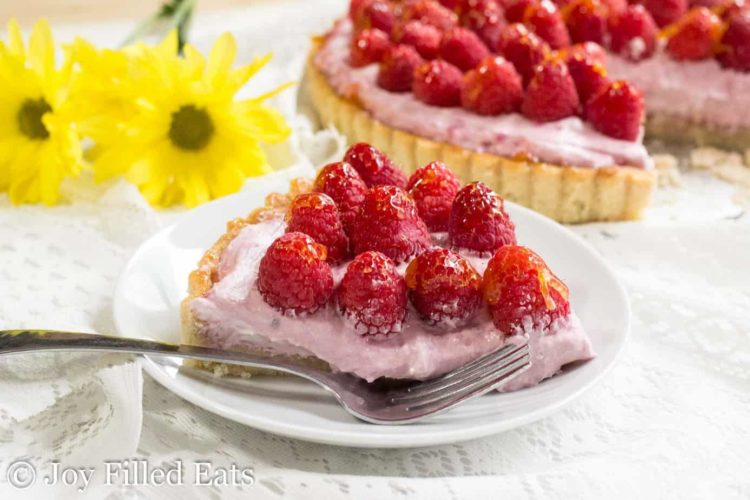 slice of raspberry mousse tart on a plate with a fork