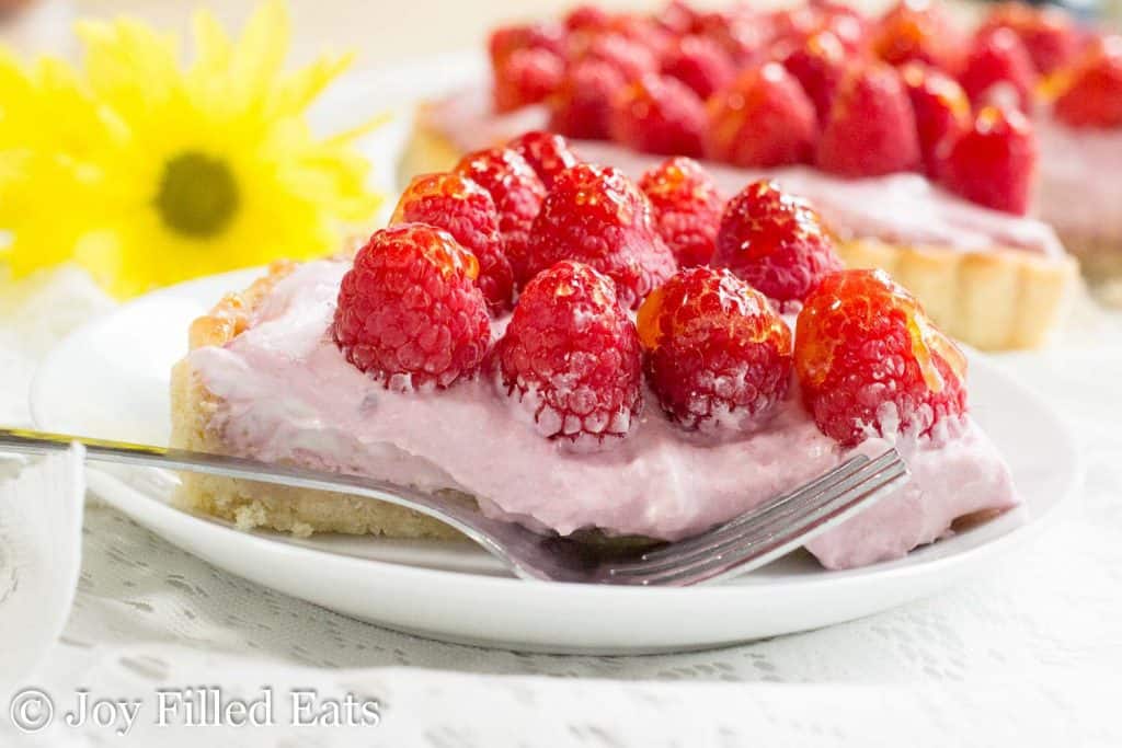 slice of raspberry mousse tart on a plate with fork