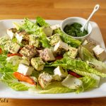 Grilled Paneer Salad and cilantro-mint chutney on a white square plate