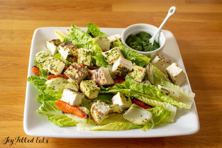 Grilled Paneer Salad and cilantro-mint chutney on a white square plate