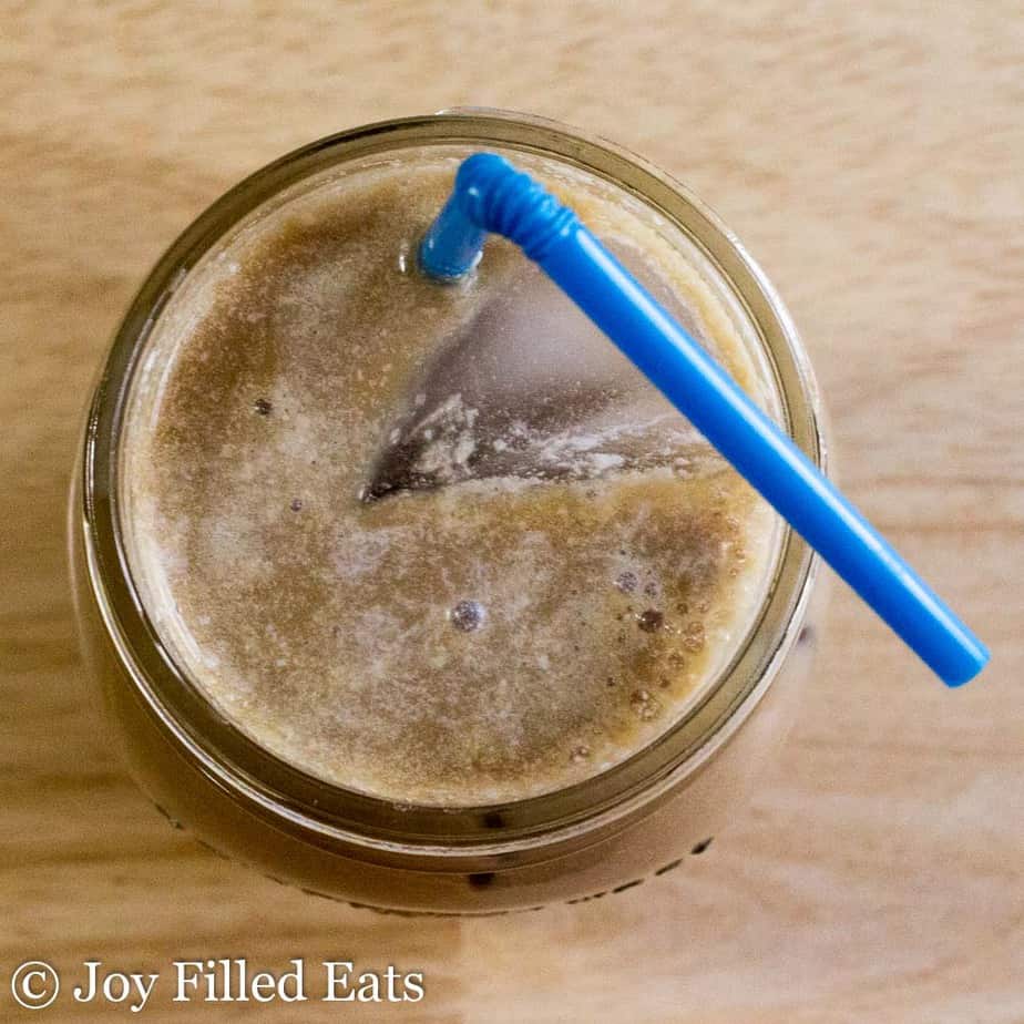 overhead view of drink containing Monkfruit Coffee Creamer in a mason jar with blue straw