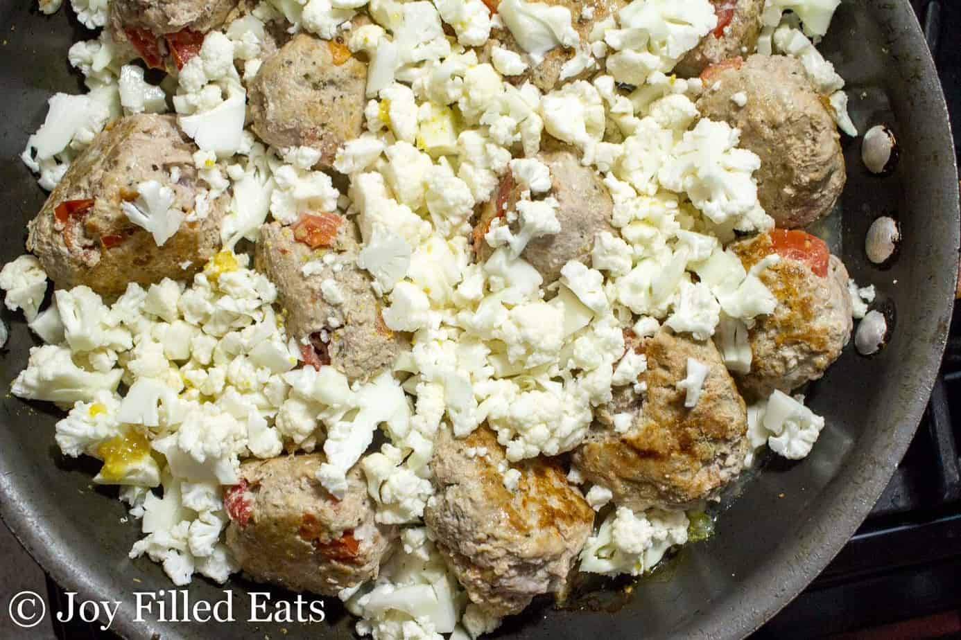 diced cauliflower added into skillet with Basil & Tomato meatballs