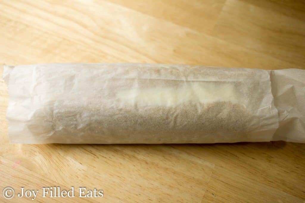 Mini Pumpkin Cake Roll with Cream Cheese Icing rolled in parchment paper