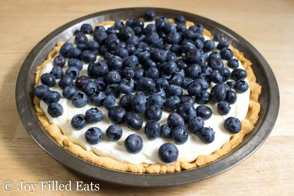 Lemon Ricotta Pie topped with fresh blueberries in a pie tin
