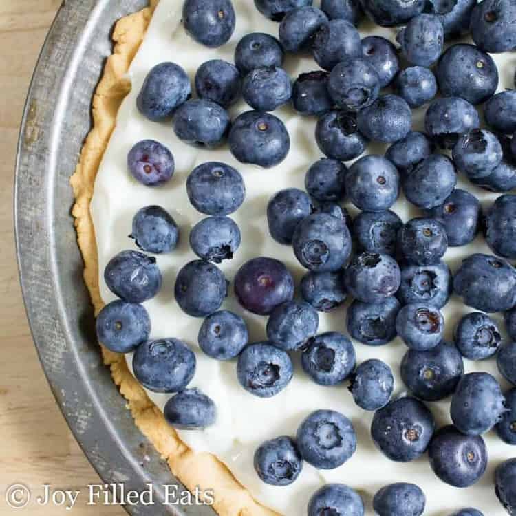 Lemon Ricotta Pie topped with fresh blueberries in a pie tin close up