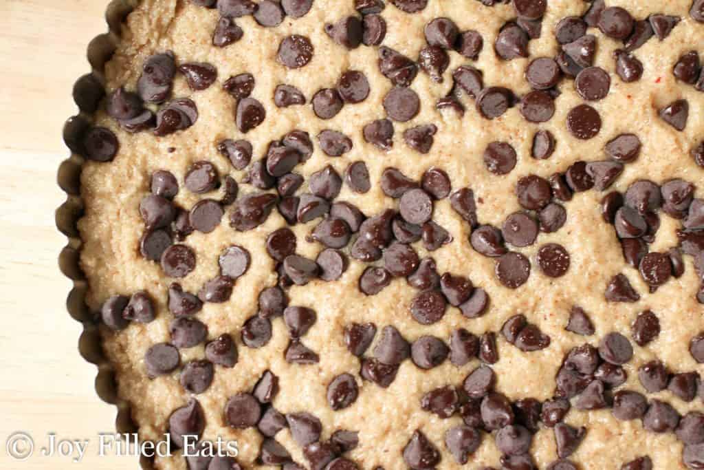 Nutty Chocolate Chip Cookie dough in pie plate topped with chocolate chips