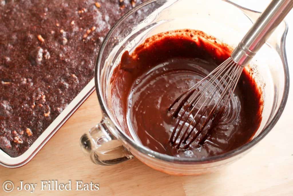 measuring cup of melted chocolate with a whisk