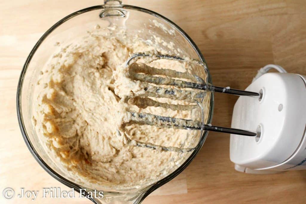 cinnamon pecan crumb cake batter in a mixing bowl with hand mixer