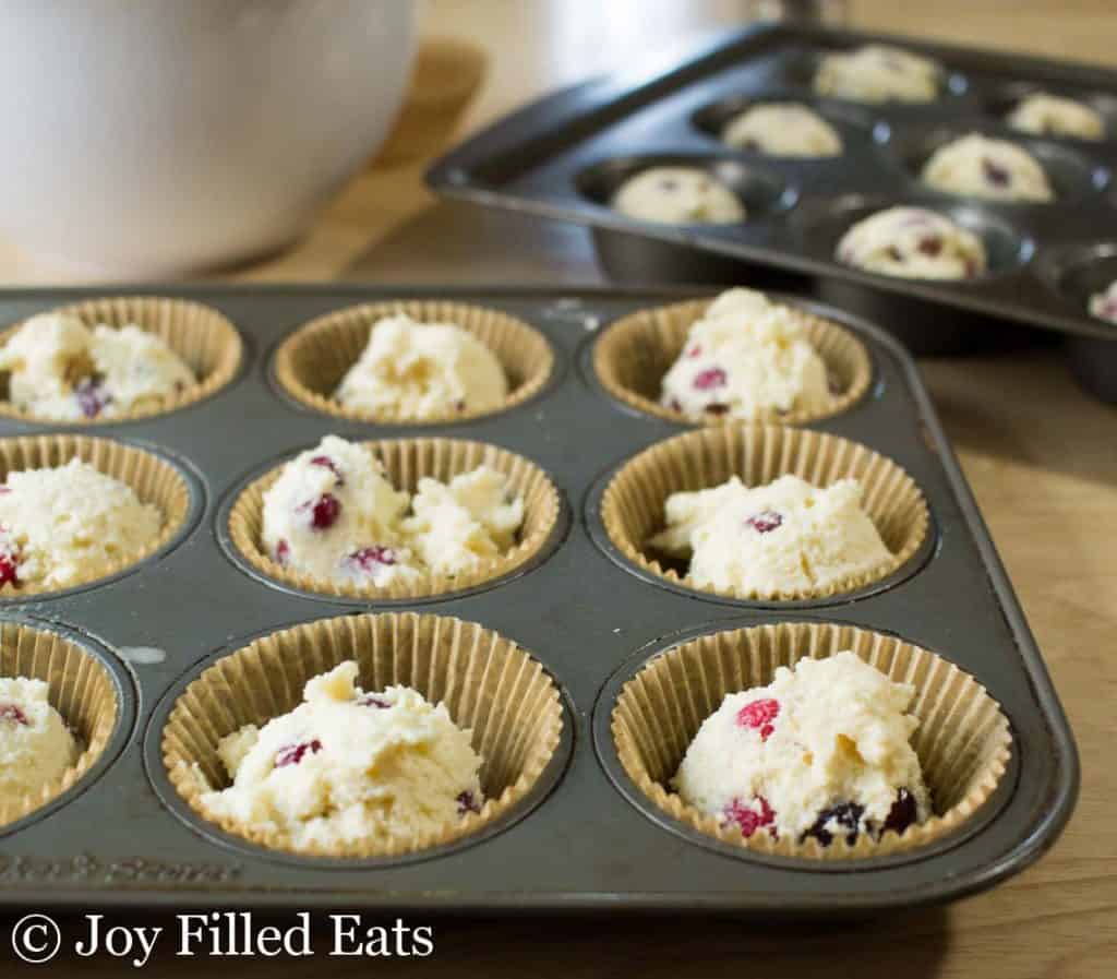 cranberry orange muffin dough placed in a wrapper lined muffin tin