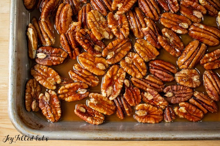 Pecans layered on a caramel sauce in a baking dish