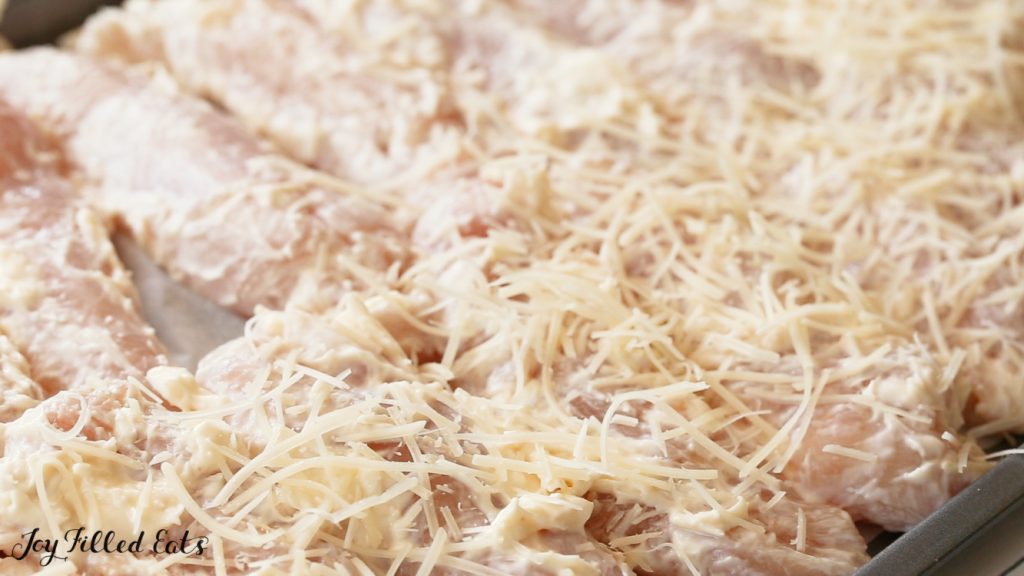 close up of garlic parmesan chicken tenders lined in sheet pan