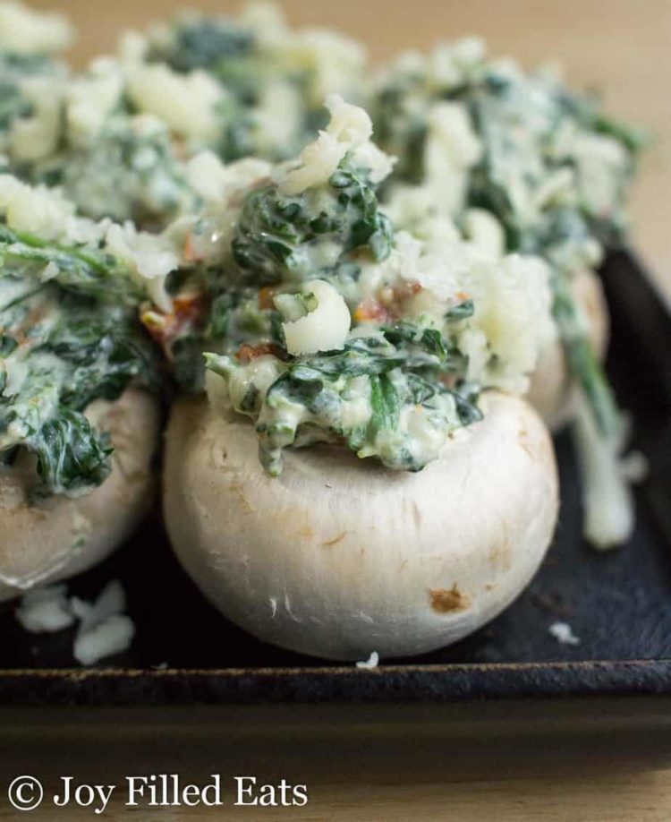 close up on spinach stuffed mushroom on baking sheet before baking