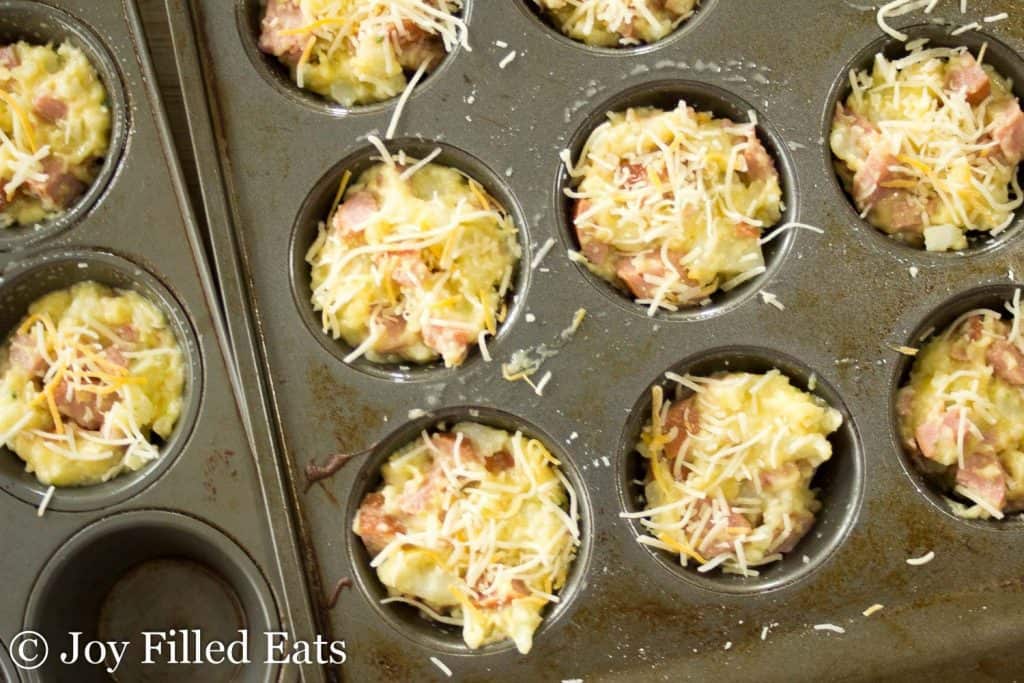 overhead view of mini muffin tin filled with smokey mac and cheese bites before baking