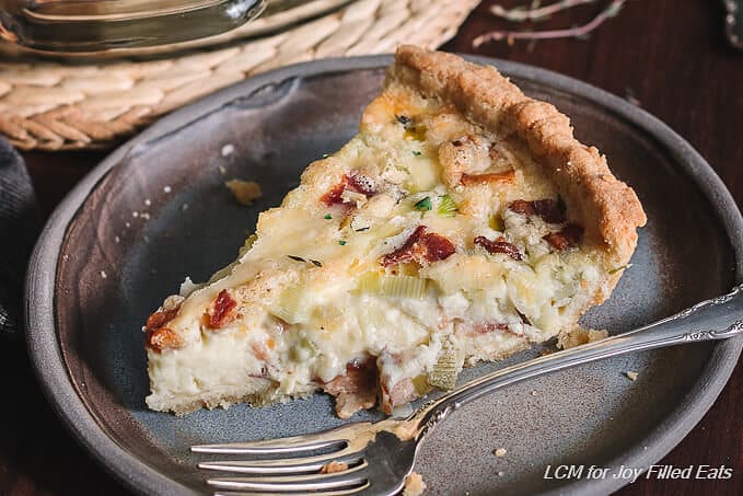 slice of bacon & leeks quiche on a plate with fork