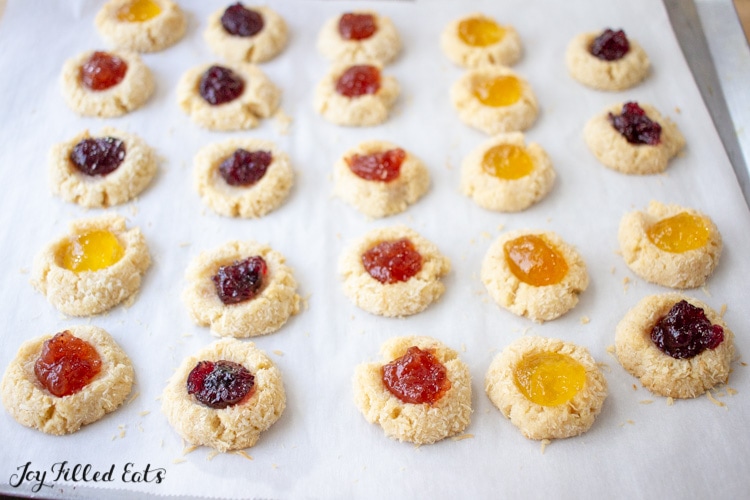 baking sheet lined with parchment full of jam thumbprint cookies