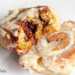a cinnamon roll with a bite out of it on a white plate