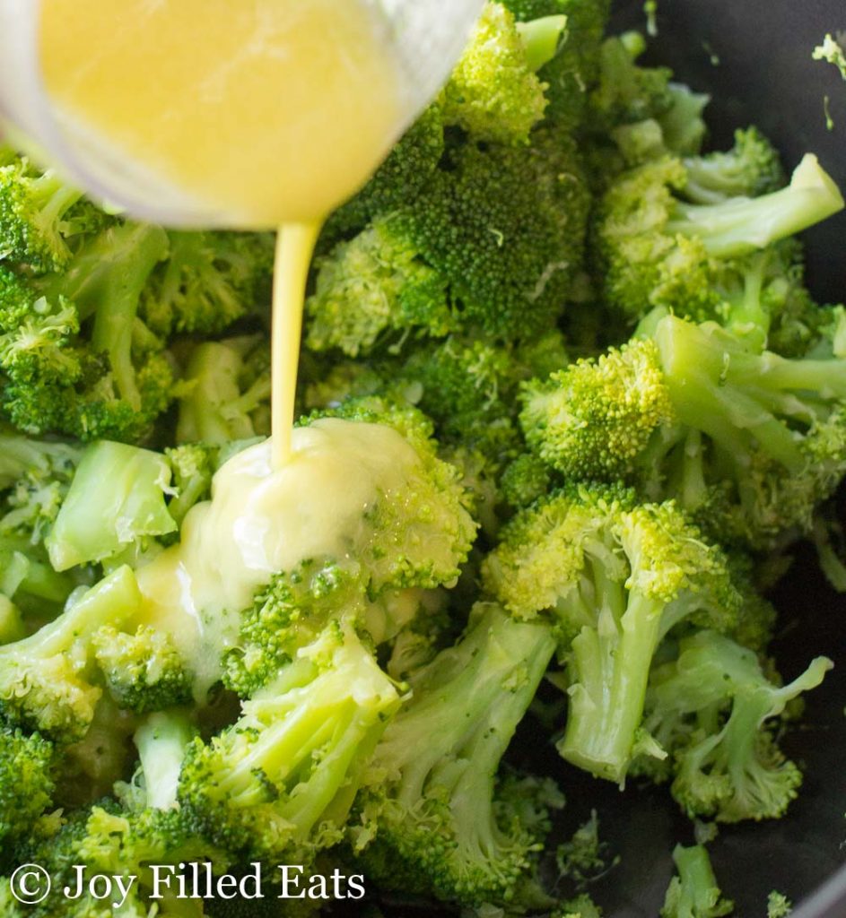 lemon & garlic sauce being poured onto broccoli florets