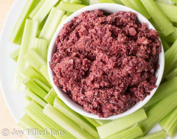 overhead view of olive tapenade surrounded by celery sticks