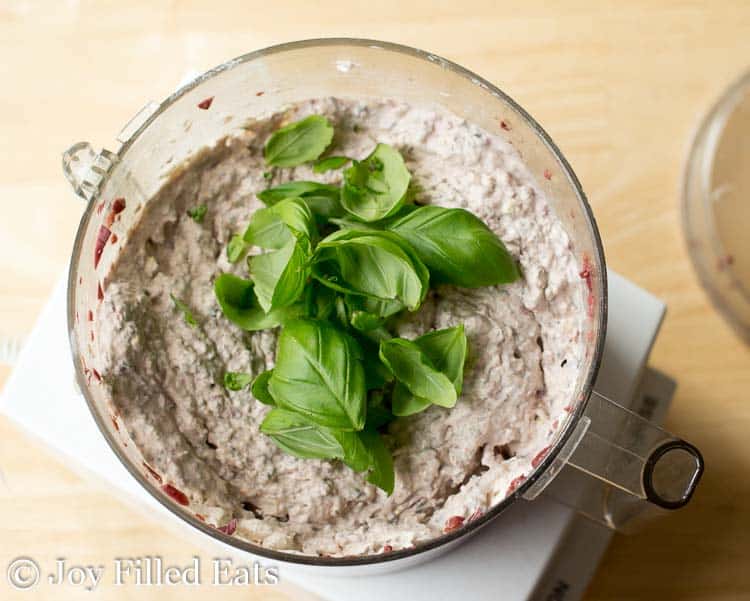close up of Mediterranean cheese spread mixture topped with baby spinach