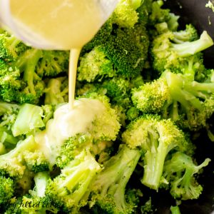 close up of pouring the lemon garlic dressing over the garlicy keto broccoli side dish recipe