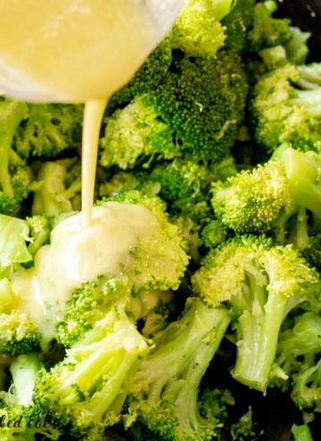 close up of pouring the lemon garlic dressing over the garlic broccoli side dish recipe