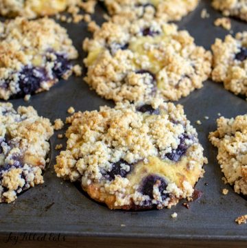 muffin tin full of low carb blueberry muffins with crumb topping