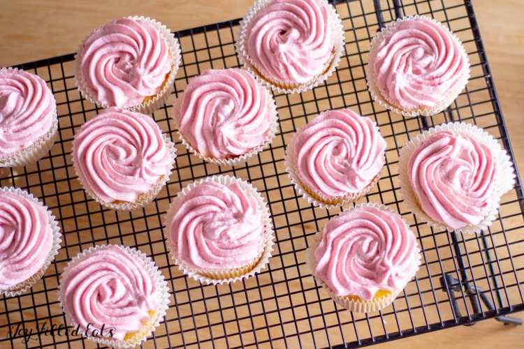 raspberry frosted topped raspberry lemonade cupcakes arranged on a cooling rack