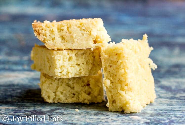 stack of white chocolate blondies with one blondie leaning on the stack