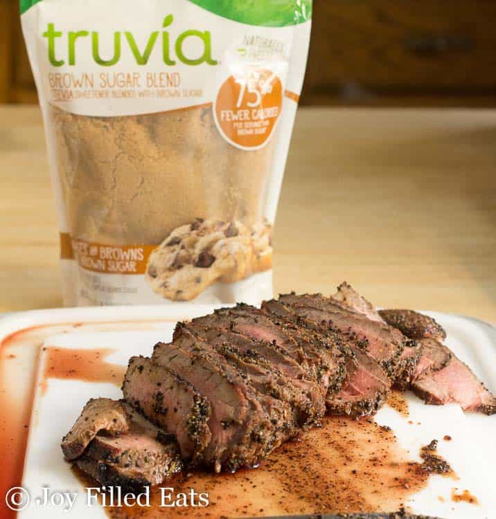 grilled london broil sliced on a cutting board next to a package of Truvia brown sugar blend