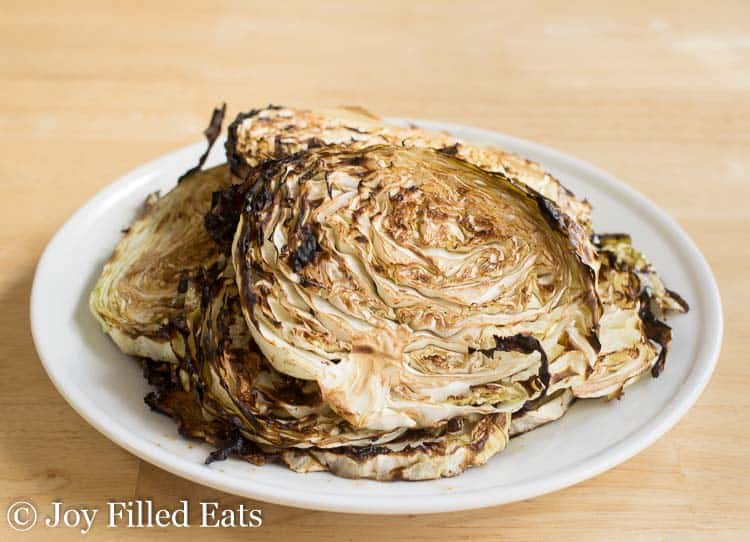 pile of roasted cabbage steaks on a white plate