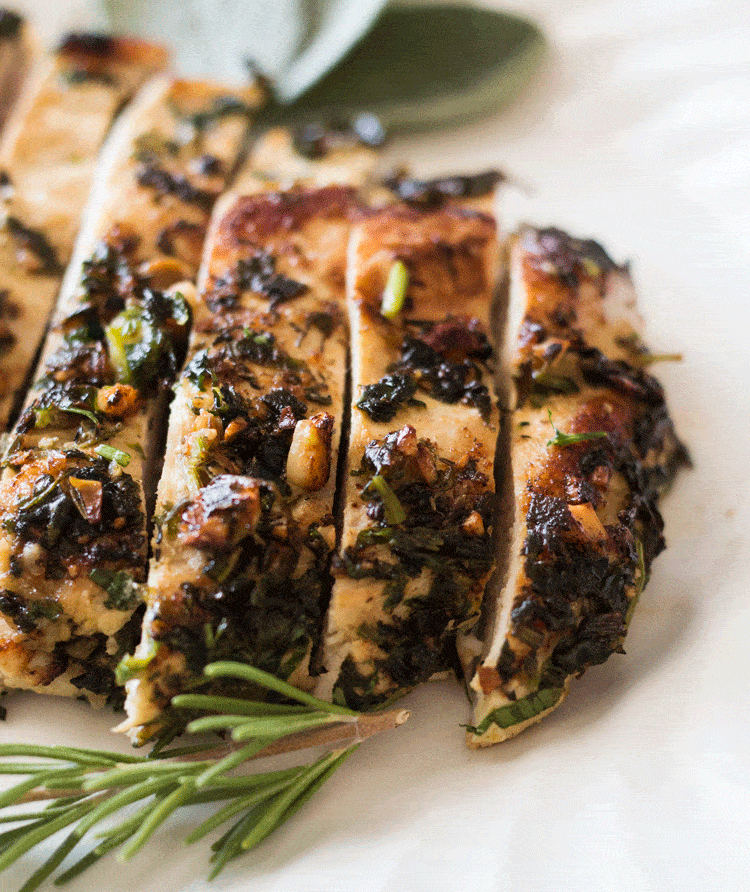 Up close image of Macadamia Nut Chicken Breasts surrounded by sage and rosemary