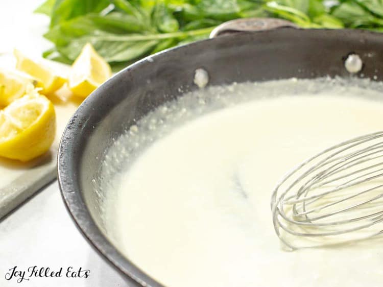 creamy lemon sauce in skillet with whisk