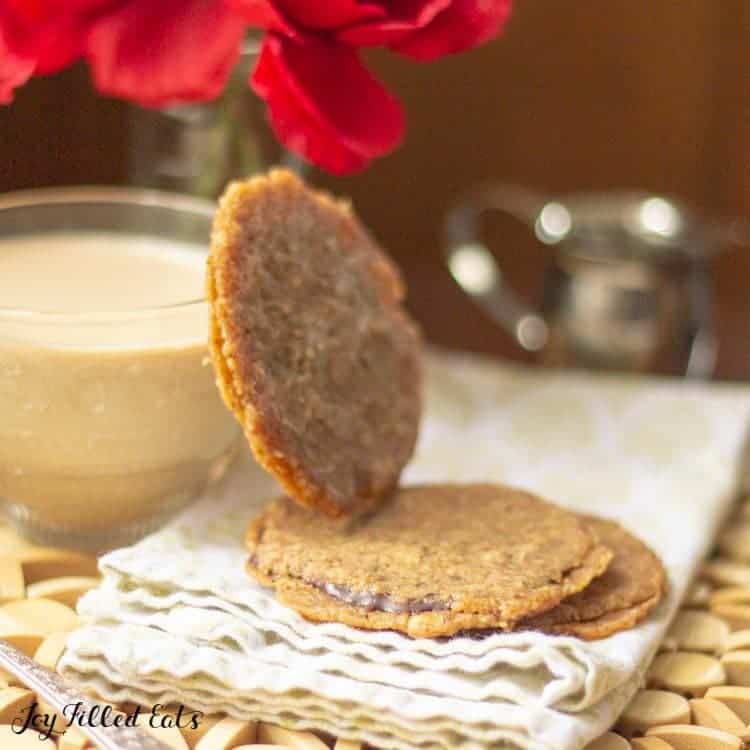 small stack of florentine cookies with one cookie leaning on a glass cup of coffee
