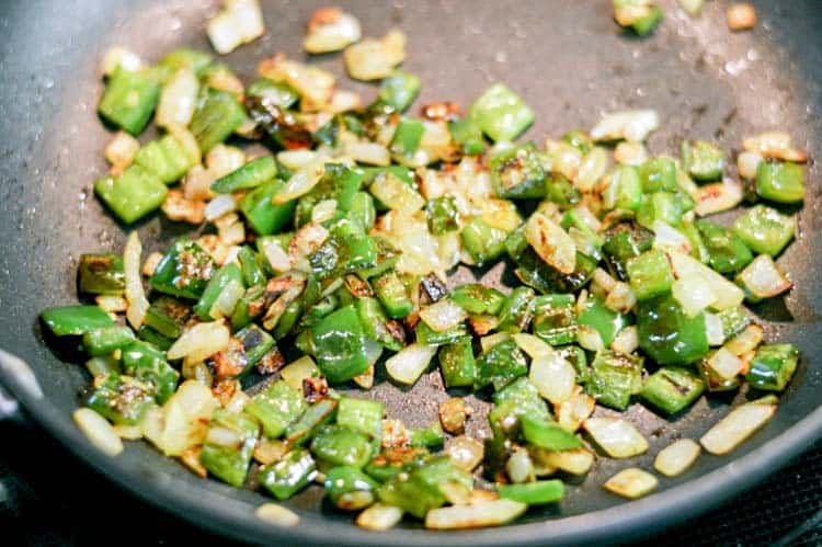 diced poblano peppers and onions sauteing in skillet