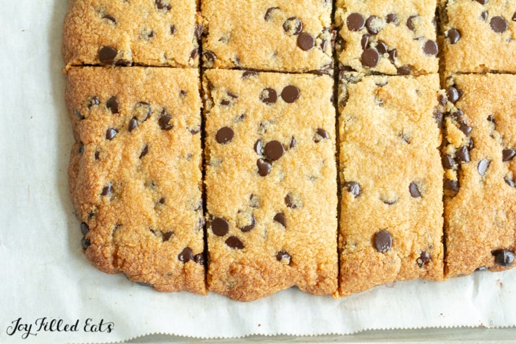 chocolate chip cookie bars cut into rectangle shapes on parchment paper close up