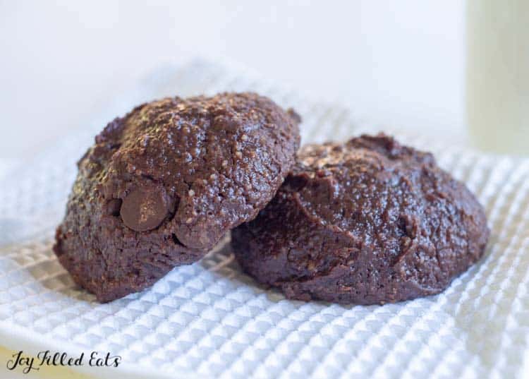 two brownie cookies on a white cloth napkin