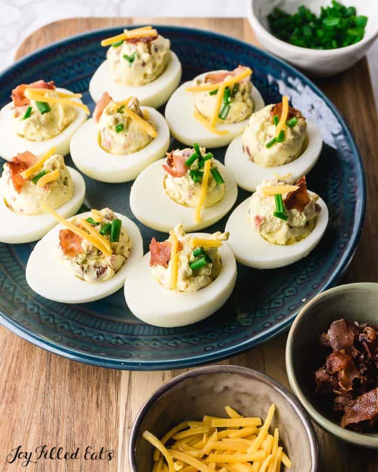 Blue plate of keto deviled eggs with bacon