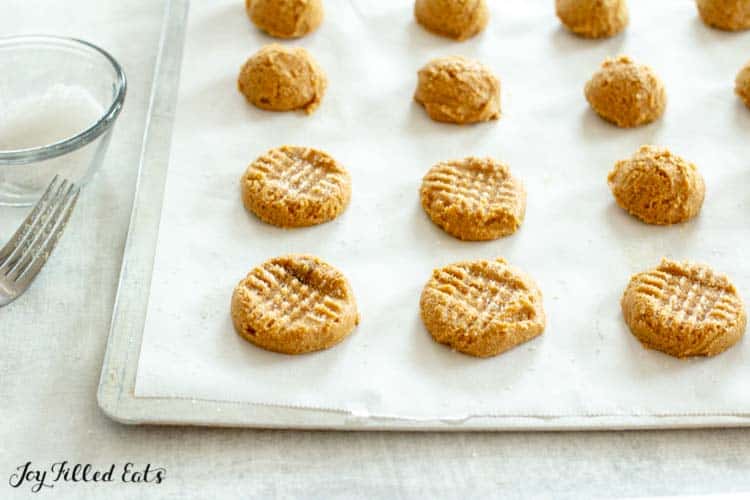circles of dairy-free peanut butter cookies dough on parchment paper lined cookie sheet