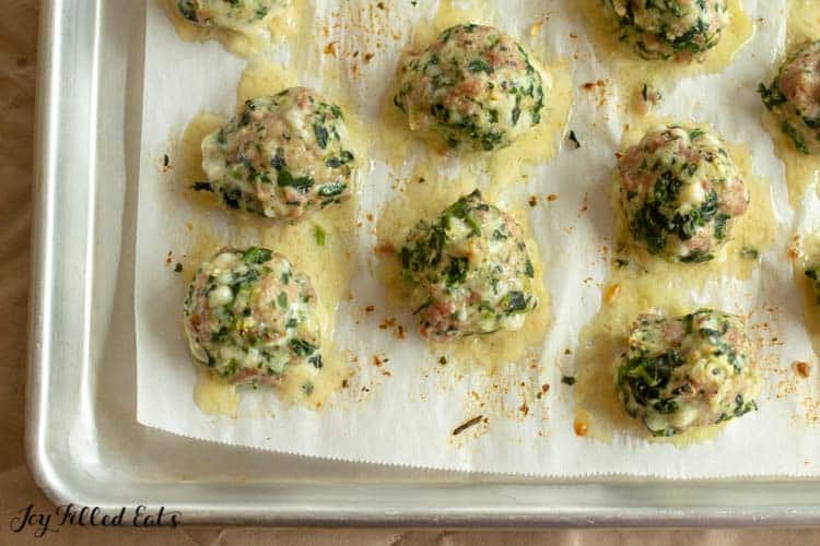 parchment lined sheet pan of italian sausage meatballs
