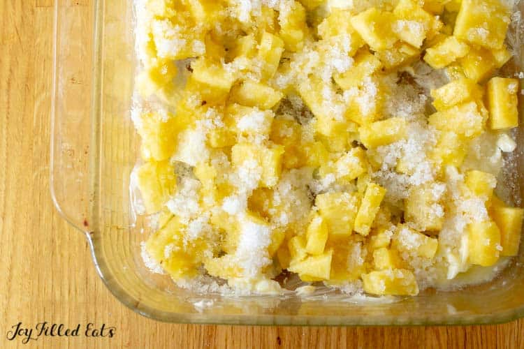 pineapple and sweetener topping layered on bottom of baking dish for pineapple upside down cake