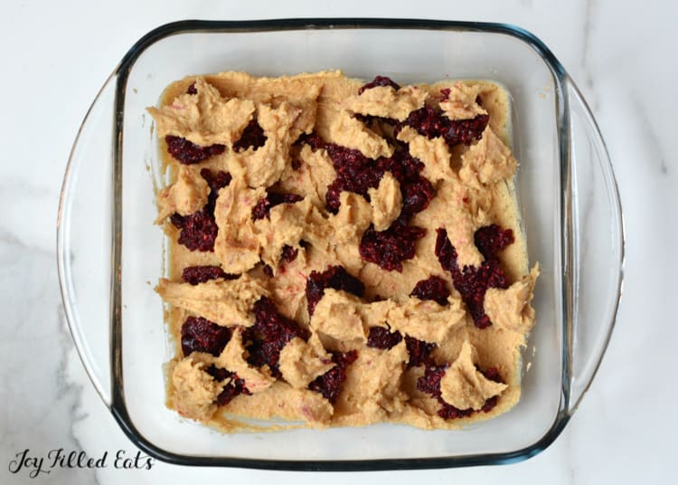 peanut butter bars with jam batter dolloped into baking dish